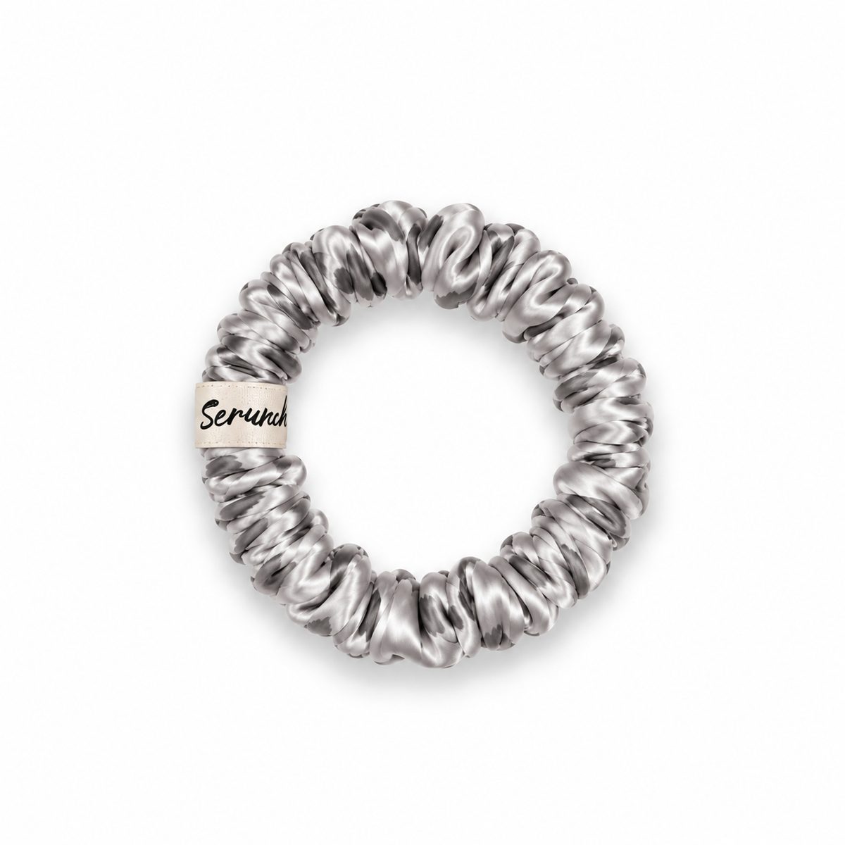 Chouchou fin en soie Scrunch'it Silk gris, avec étiquette crème de la marque, sur fond blanc.