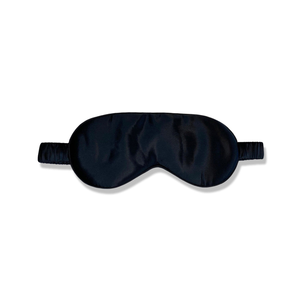 Masque de sommeil en soie noir disposé sur fond blanc - Scrunch'it Silk
