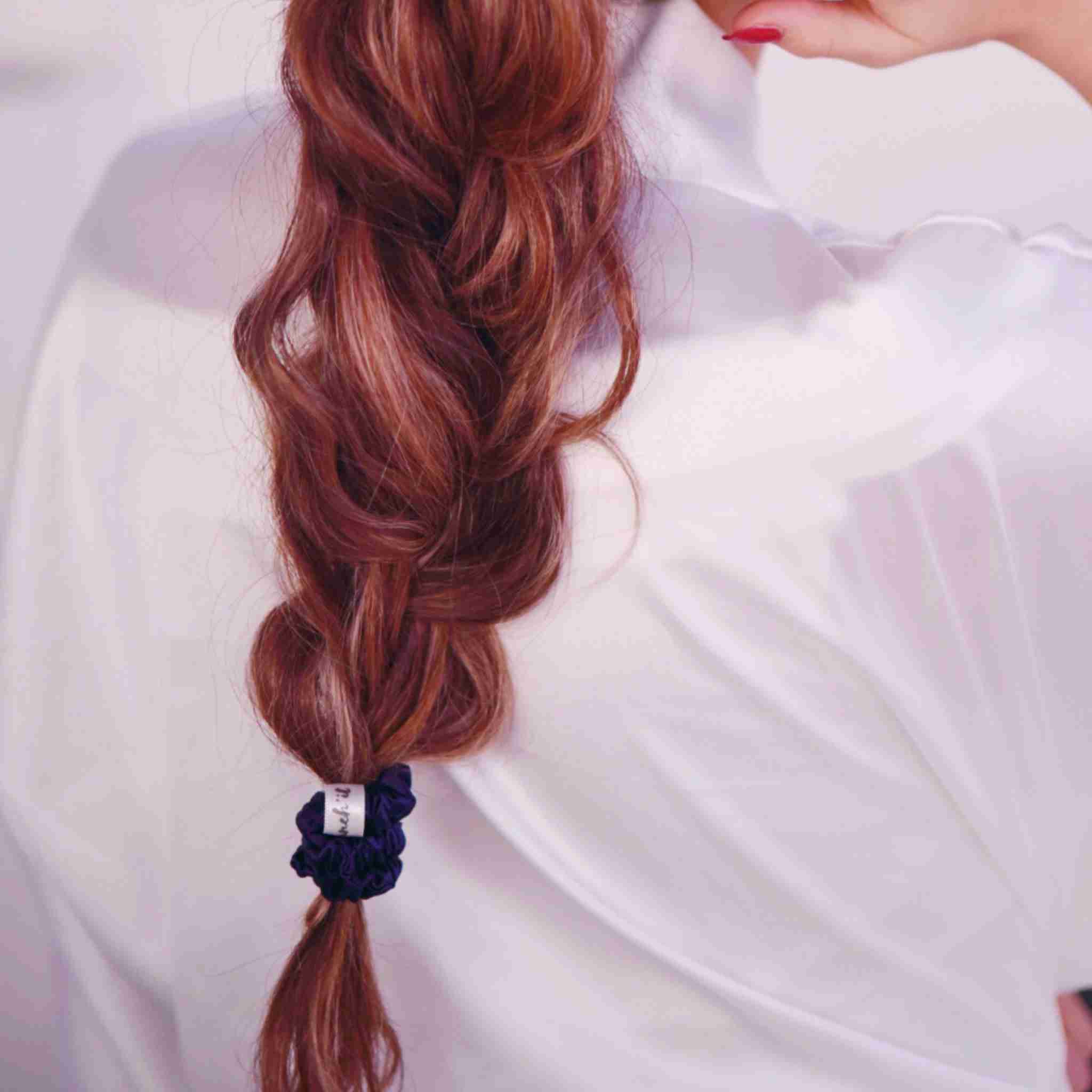 Accessoire cheveux chouchou en soie de mûrier de taille Small, en bleu. Elastique en pure soie, fin, pour protéger les cheveux de la casse et attacher les cheveux sans les abîmer et sans laisser de trace. Accessoire chic et romantique pour les coiffures pour femme. Ici porté en tresse sur cheveux blonds.