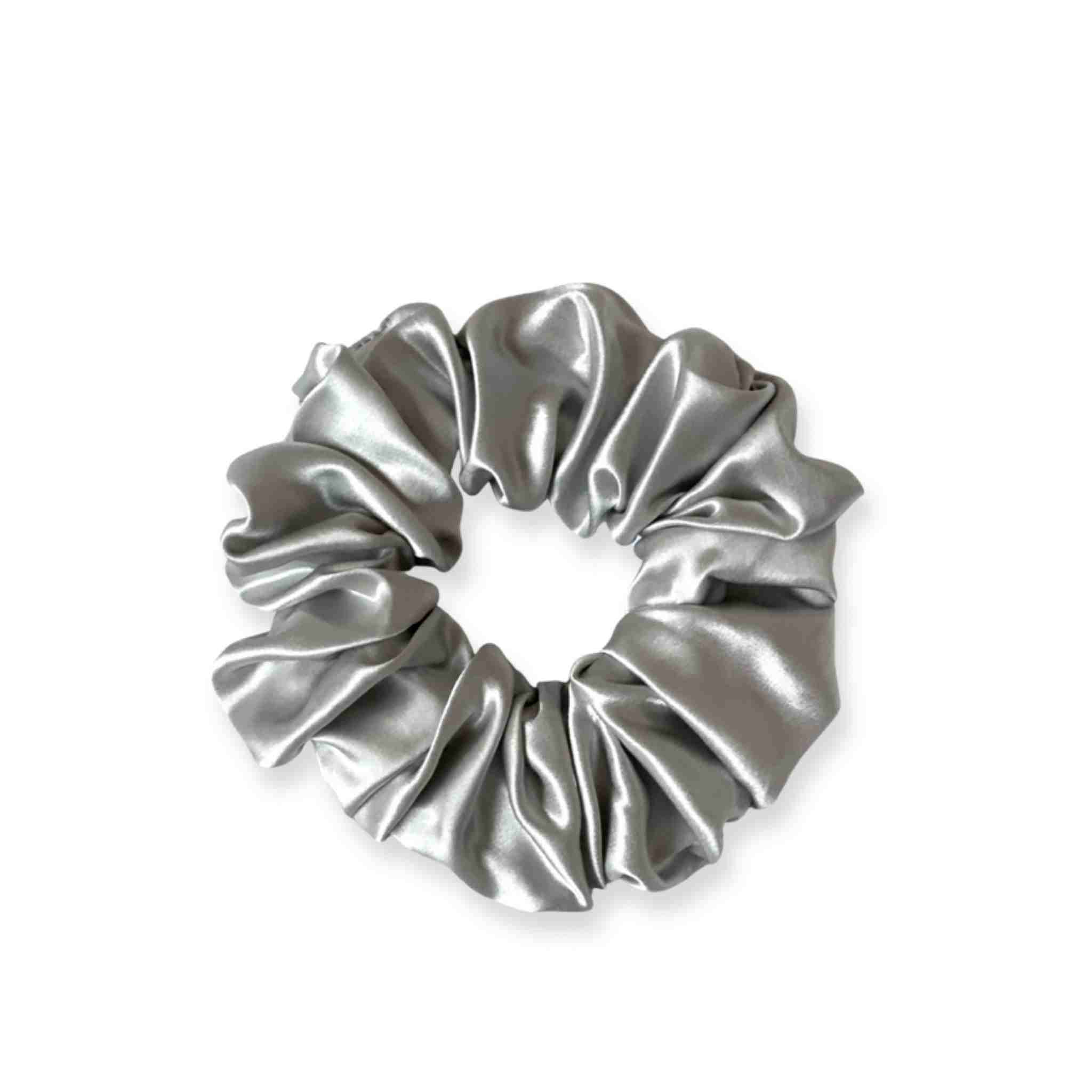 Accessoire cheveux chouchou en soie de mûrier de taille large, en argenté. Elastique en soie pure pour protéger les cheveux de la casse et attacher les cheveux sans les abîmer et sans laisser de trace. Accessoire chic et romantique pour les coiffures pour femme.