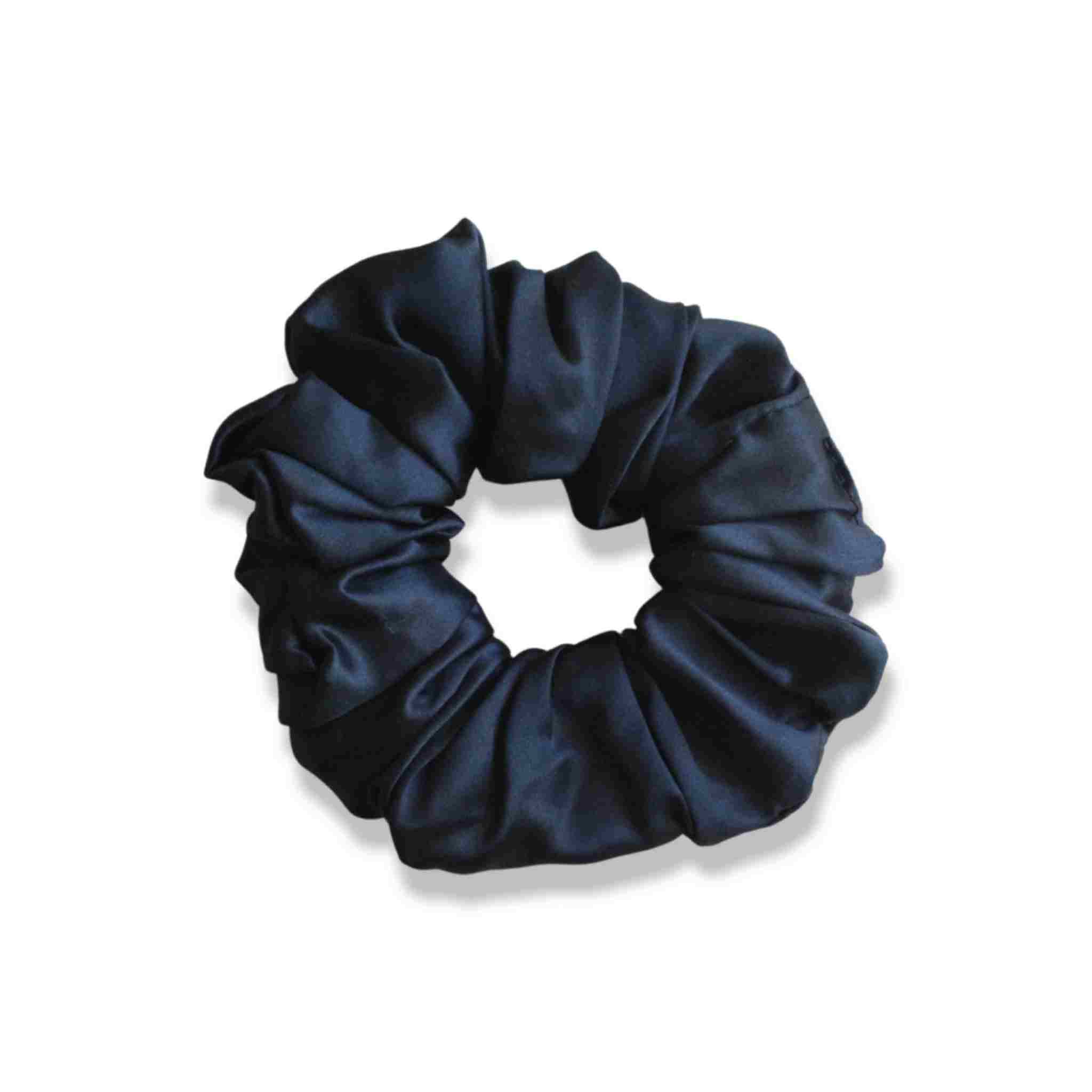Accessoire cheveux chouchou en soie de mûrier de taille large, en noir. Elastique en soie pure pour protéger les cheveux de la casse et attacher les cheveux sans les abîmer et sans laisser de trace. Accessoire chic et romantique pour les coiffures pour femme