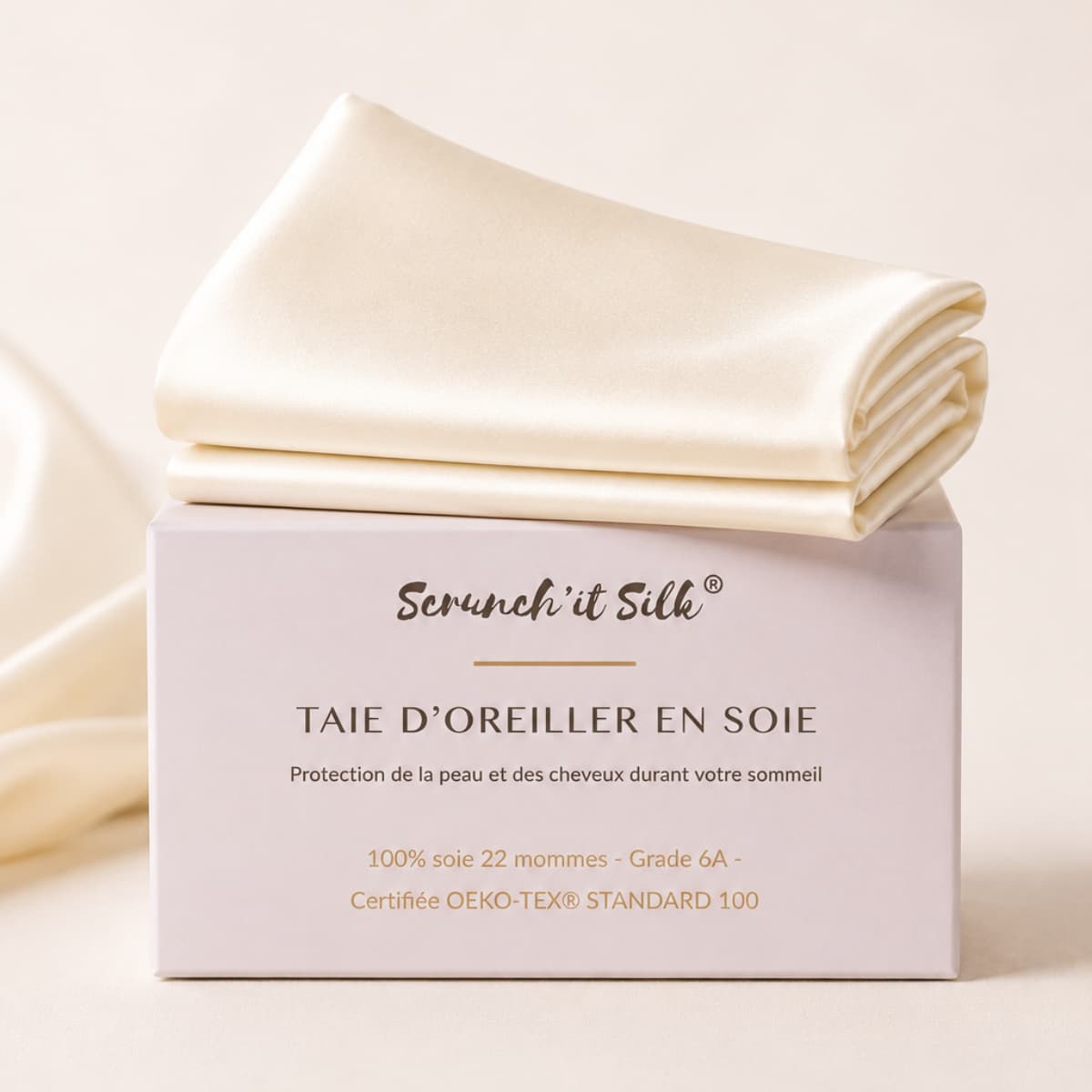 Taie d'oreiller en soie de mûrier ivoire pliée sur sa boite Scrunch'it Silk.
