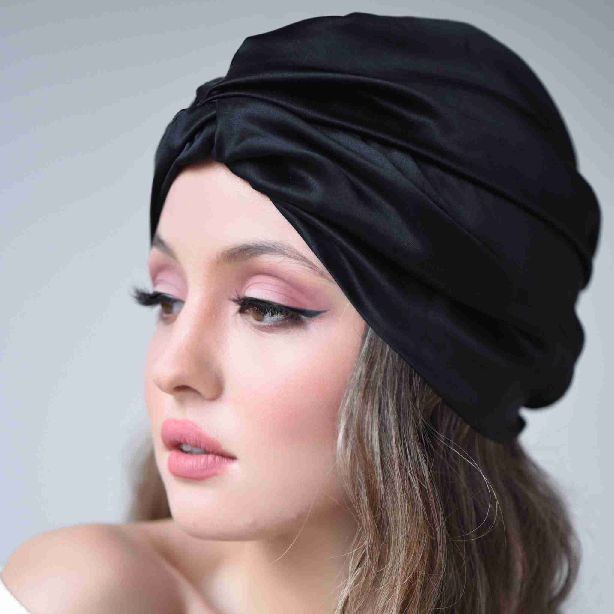 Turban pour femme en soie de la marque Scrunch'it, bonnet de nuit noir en soie à porter en dormant pour protéger les cheveux des frictions qui fragilisent les cheveux. Matière 100% soie de mûrier de haute qualité pour cheveux bouclés et afro.