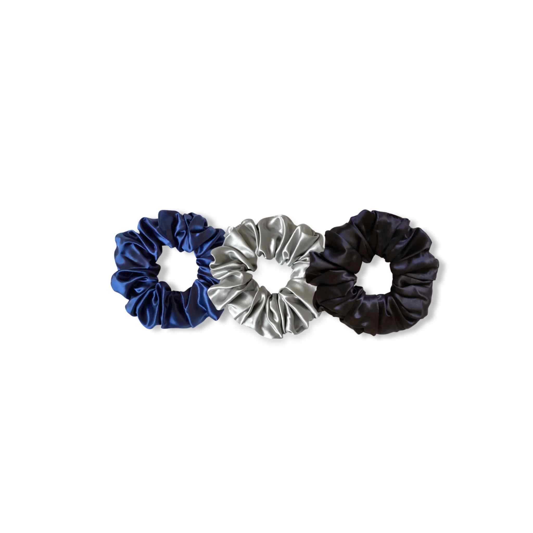 Accessoires cheveux chouchous en soie de mûrier de taille large, en noir, bleu et argenté. Pack de trois élastiques en soie pure pour protéger les cheveux de la casse et attacher les cheveux sans les abîmer et sans laisser de trace. Accessoire chic et romantique pour les coiffures pour femme.